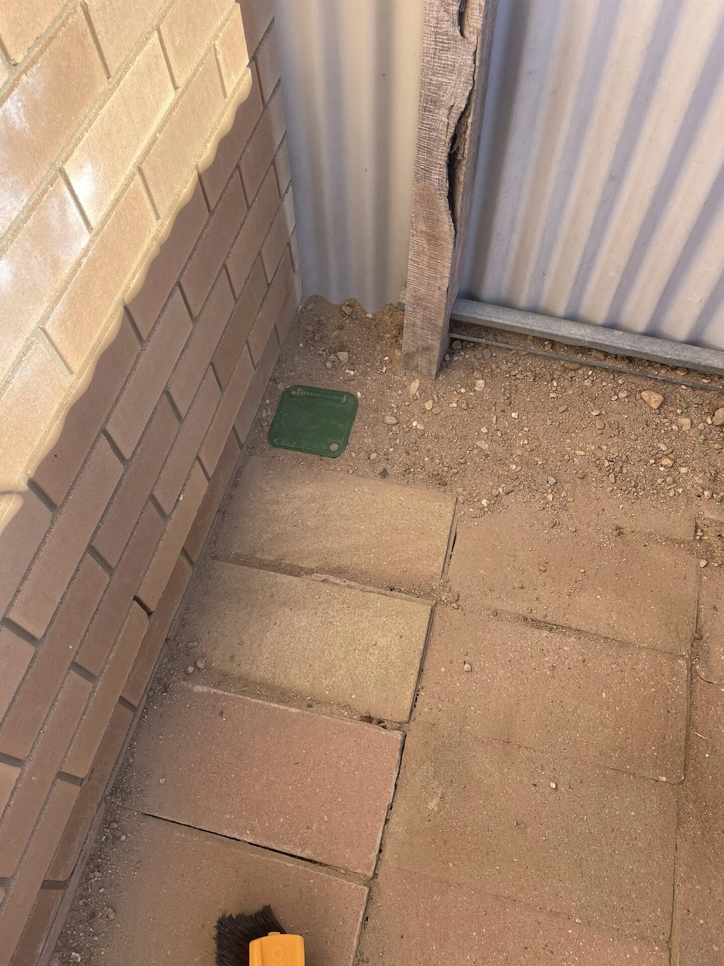 Concealed termite damage uncovered between brick walls during an inspection